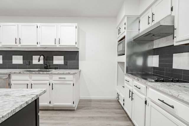 kitchen featuring white cabinetry, light stone countertops, sink, and light wood-type flooring