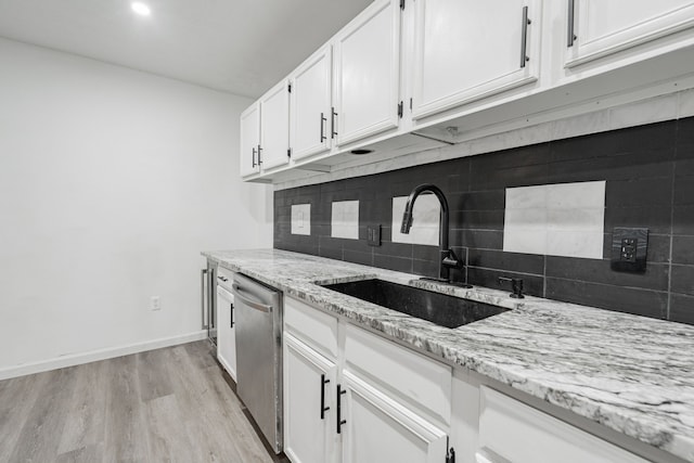 kitchen featuring white cabinetry, light stone countertops, dishwasher, light hardwood / wood-style floors, and sink