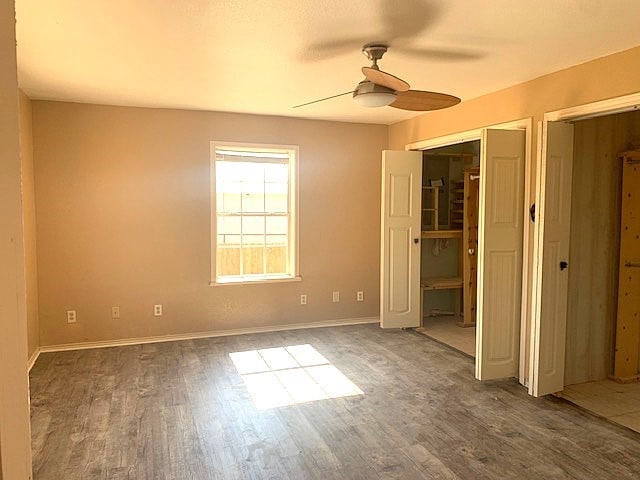 unfurnished bedroom featuring ceiling fan and dark hardwood / wood-style flooring