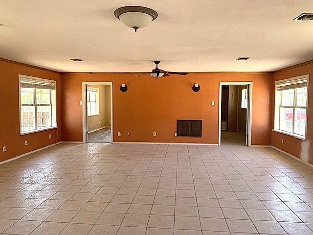 tiled spare room with ceiling fan