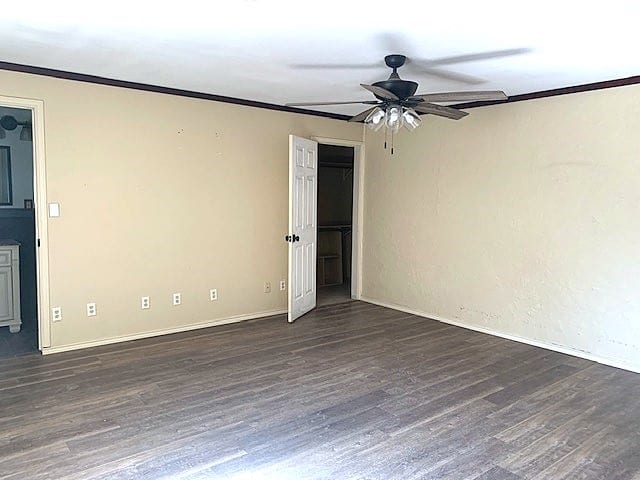 empty room featuring ornamental molding, ceiling fan, and dark hardwood / wood-style flooring