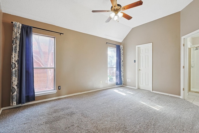 carpeted spare room featuring ceiling fan and lofted ceiling