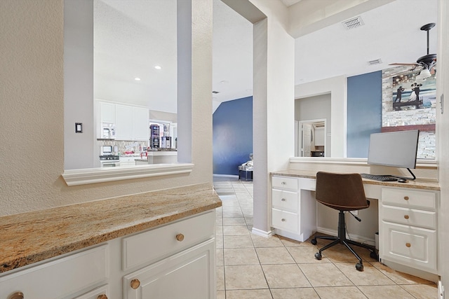 office area with built in desk, ceiling fan, and light tile patterned flooring