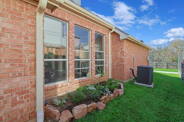 view of property exterior with central AC and a lawn