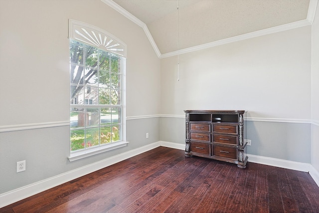 spare room featuring a healthy amount of sunlight, dark hardwood / wood-style flooring, ornamental molding, and vaulted ceiling