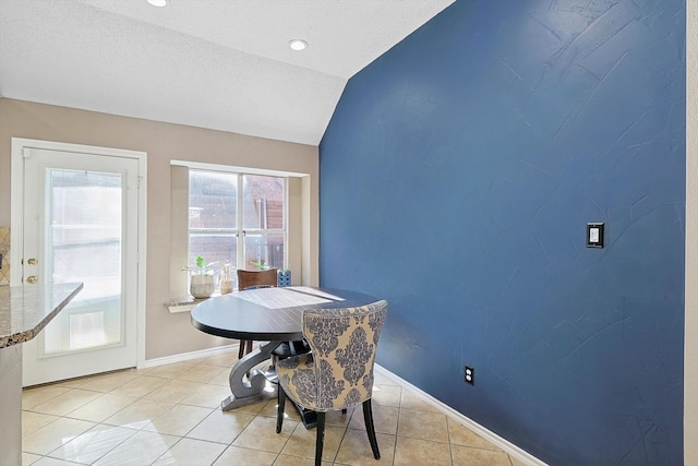 dining room with lofted ceiling and light tile patterned floors