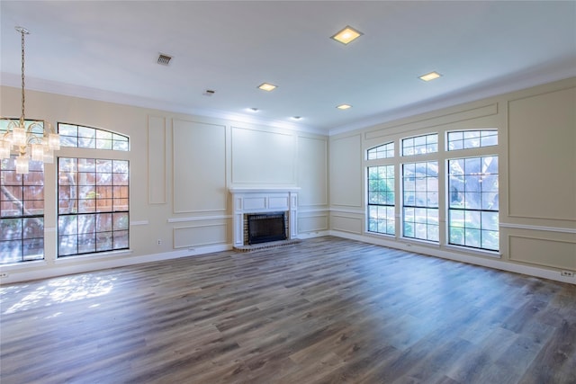 unfurnished living room with crown molding, dark hardwood / wood-style floors, and a chandelier