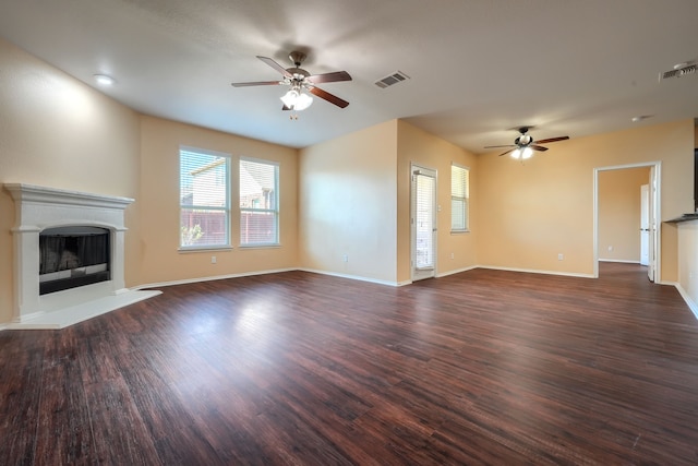 unfurnished living room featuring dark wood-type flooring and ceiling fan