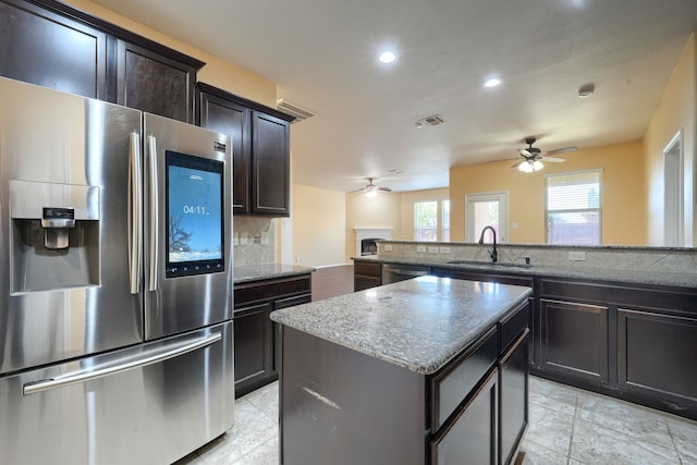 kitchen with tasteful backsplash, sink, a center island, ceiling fan, and stainless steel appliances