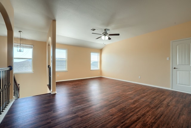 unfurnished room with ceiling fan, a textured ceiling, a healthy amount of sunlight, and dark hardwood / wood-style flooring