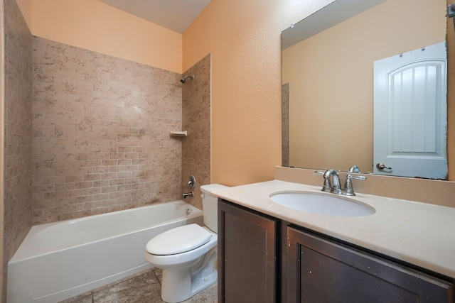 full bathroom featuring vanity, tiled shower / bath, and toilet