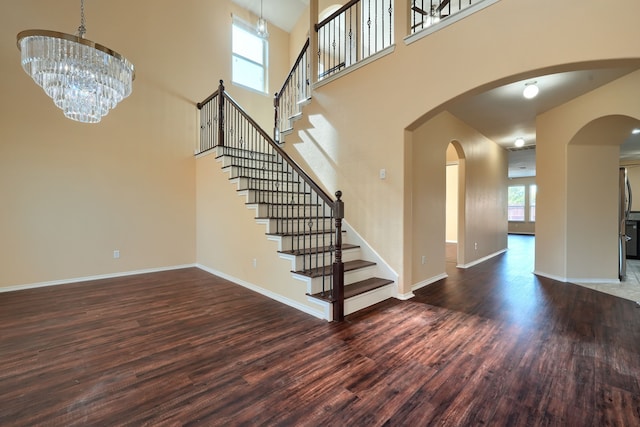 interior space featuring dark hardwood / wood-style flooring, a chandelier, and a high ceiling