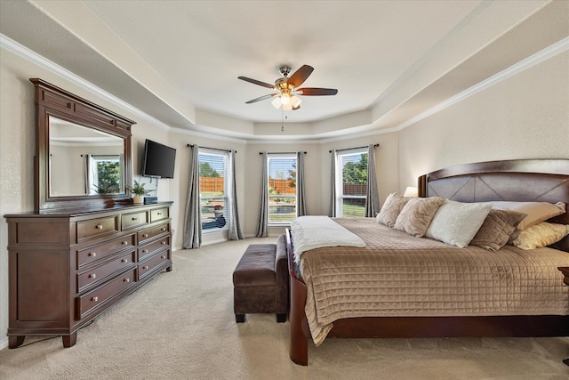 bedroom with ceiling fan, a raised ceiling, and multiple windows