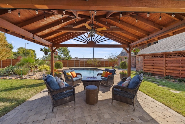 view of patio with a gazebo, ceiling fan, and an outdoor living space with a fire pit