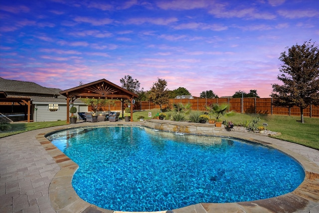 pool at dusk with a gazebo, a yard, and a patio