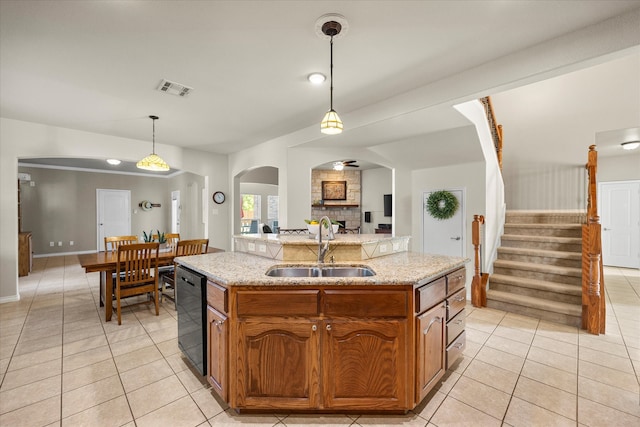 kitchen featuring a kitchen island with sink, sink, and decorative light fixtures