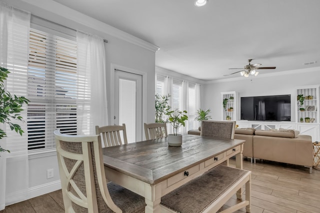 dining room featuring ceiling fan, light wood-type flooring, and crown molding