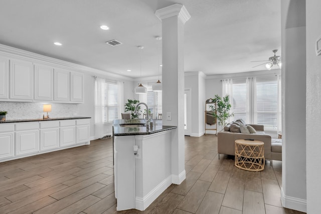 kitchen with crown molding, sink, white cabinets, and light wood-type flooring