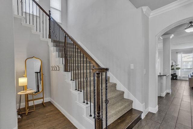 staircase featuring wood-type flooring and crown molding