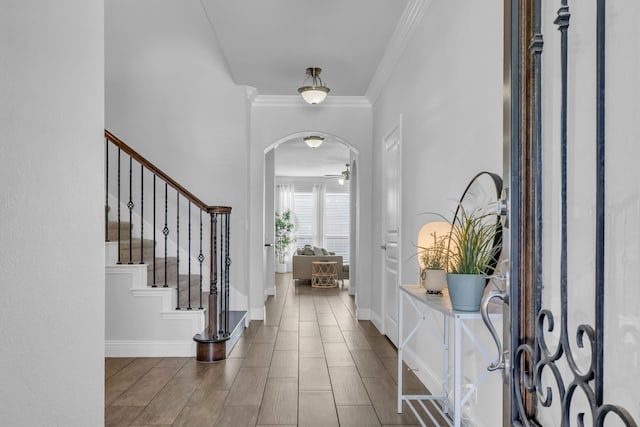 foyer featuring ceiling fan and crown molding