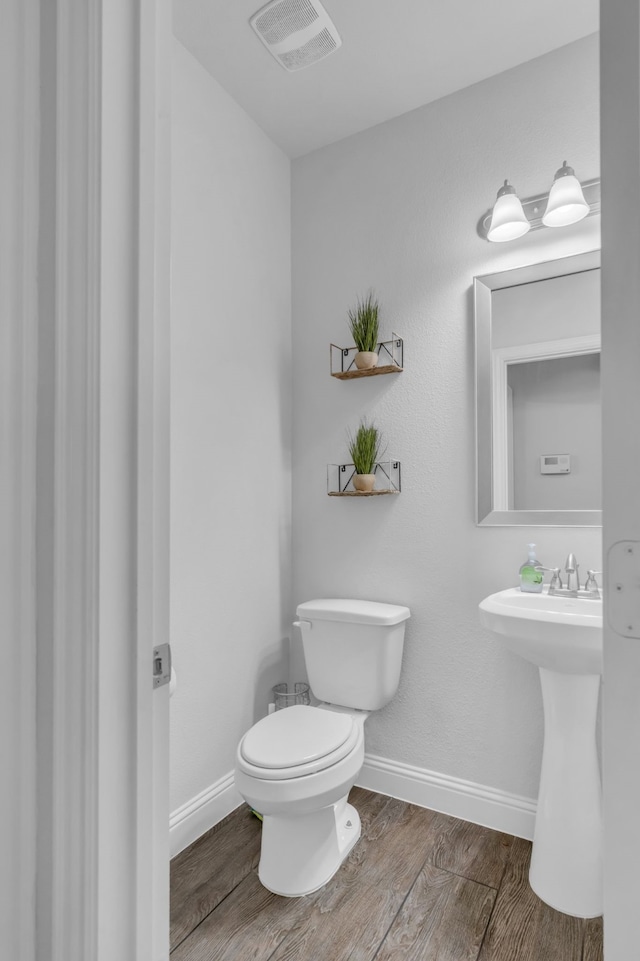 bathroom featuring toilet and hardwood / wood-style flooring