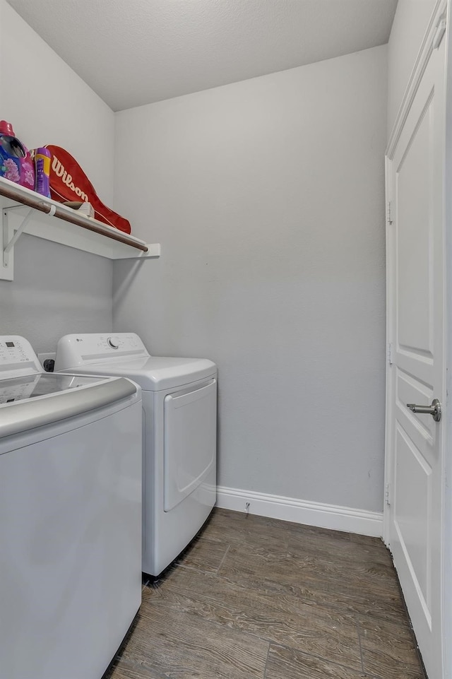 washroom with hardwood / wood-style floors and washing machine and clothes dryer