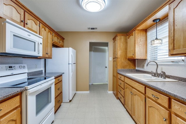 kitchen with white appliances, decorative light fixtures, and sink