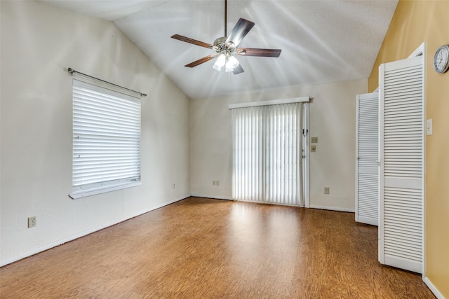 interior space featuring ceiling fan, hardwood / wood-style floors, high vaulted ceiling, and a textured ceiling