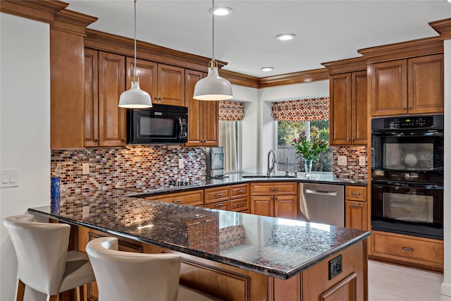 kitchen featuring decorative light fixtures, dark stone countertops, black appliances, and sink