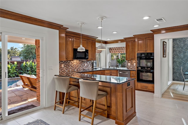 kitchen with kitchen peninsula, hanging light fixtures, backsplash, a breakfast bar, and black appliances