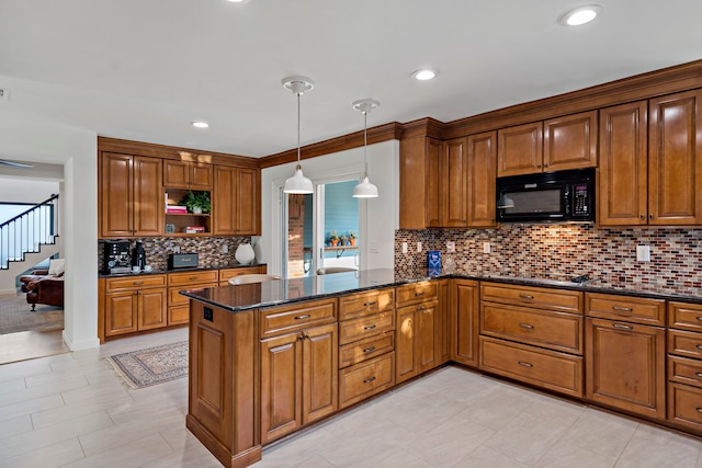 kitchen featuring kitchen peninsula, tasteful backsplash, dark stone countertops, black appliances, and pendant lighting