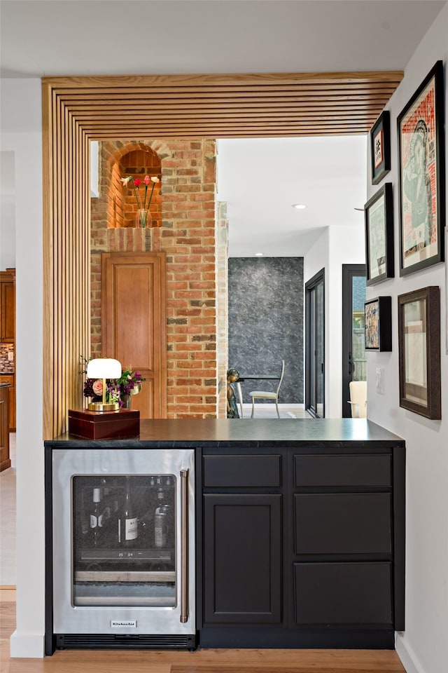 bar featuring light hardwood / wood-style flooring and wine cooler