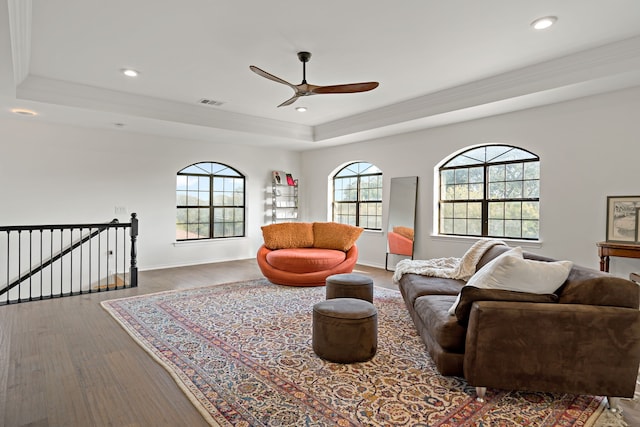 living room featuring a wealth of natural light, hardwood / wood-style floors, a tray ceiling, and ceiling fan