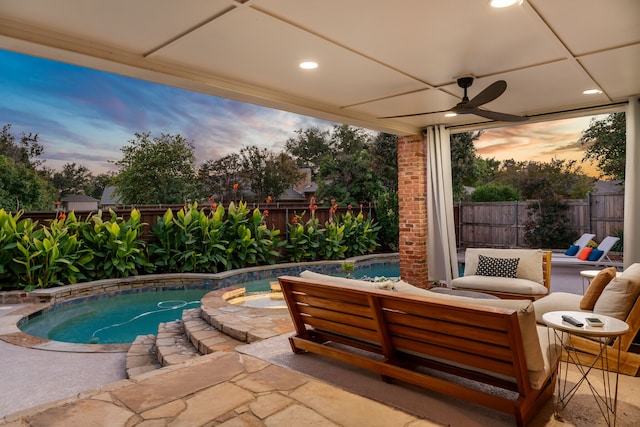 patio terrace at dusk with a fenced in pool and ceiling fan