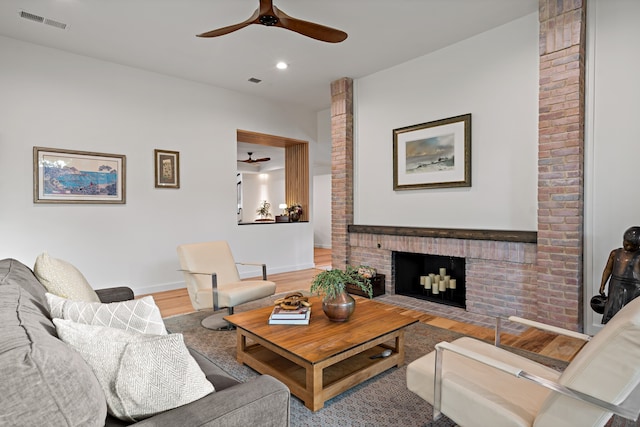 living room with hardwood / wood-style floors, a fireplace, and ceiling fan