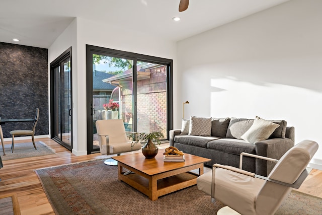 living room featuring light wood-type flooring and ceiling fan