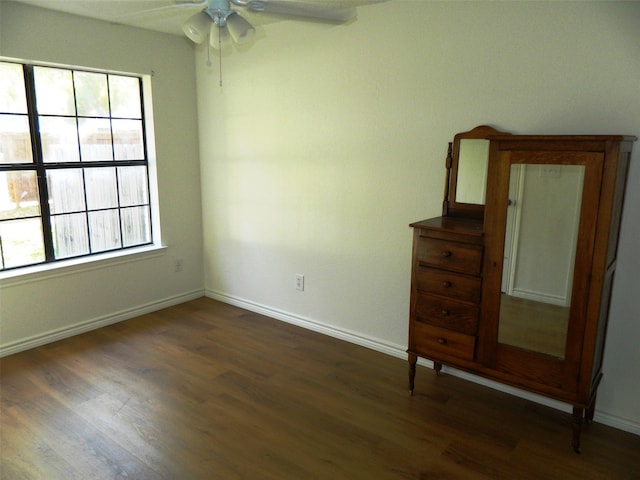 spare room featuring dark hardwood / wood-style floors, ceiling fan, and a wealth of natural light