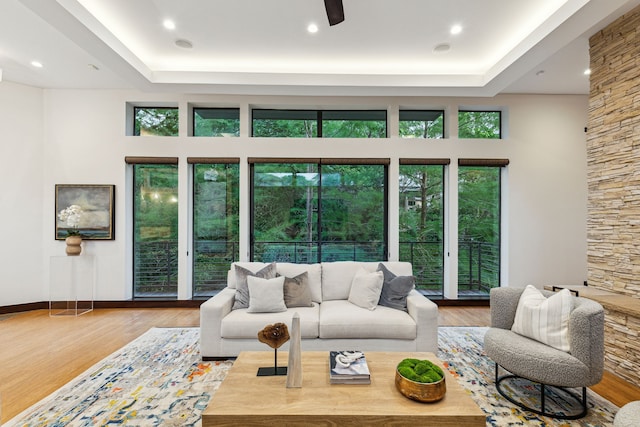 living room with light hardwood / wood-style floors, a high ceiling, and a healthy amount of sunlight