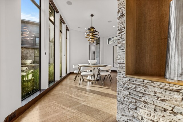 living room featuring light hardwood / wood-style flooring, a tray ceiling, a wealth of natural light, and a towering ceiling