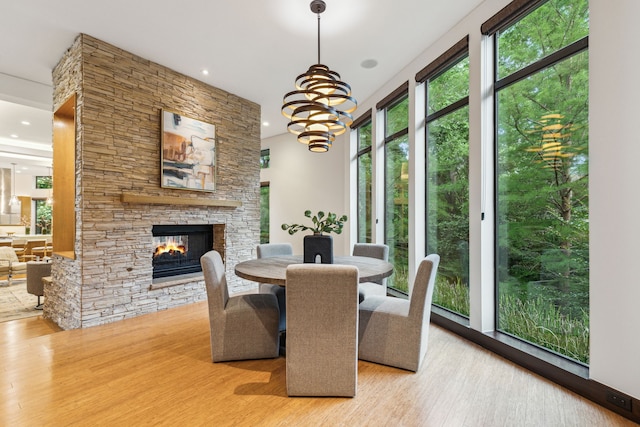 dining room with a fireplace, light hardwood / wood-style floors, and a notable chandelier