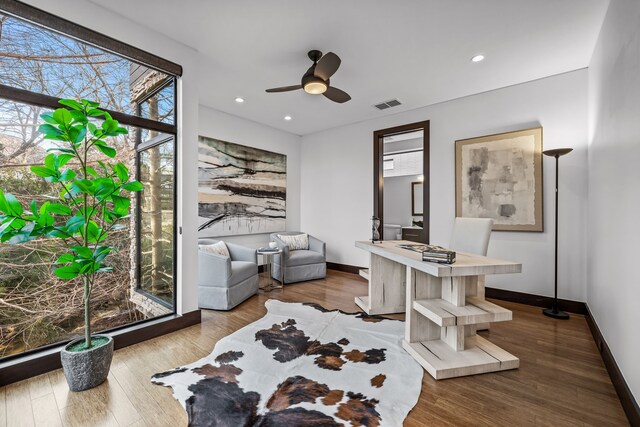 living room featuring light wood-type flooring, a tray ceiling, and ceiling fan