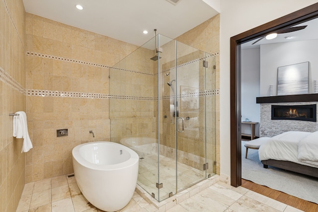 bathroom featuring independent shower and bath, tile walls, and hardwood / wood-style floors