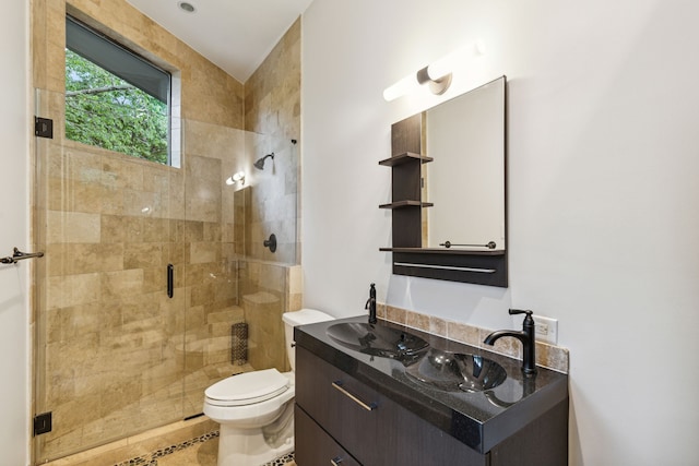 bathroom with toilet, an enclosed shower, and vanity