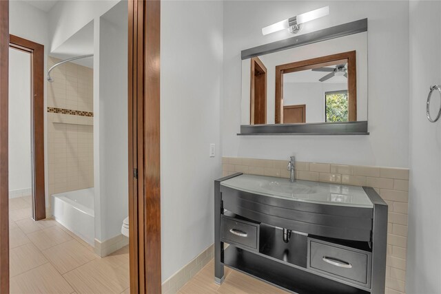 full bathroom with tile patterned floors, vanity, toilet, and tiled shower / bath combo