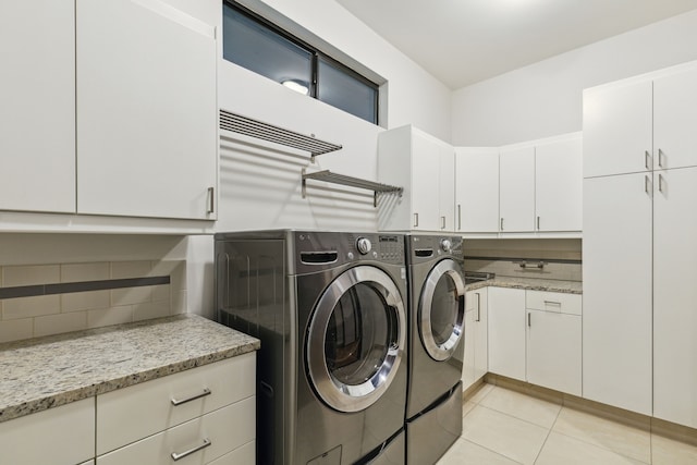 laundry room featuring cabinets, washing machine and dryer, and light tile patterned floors