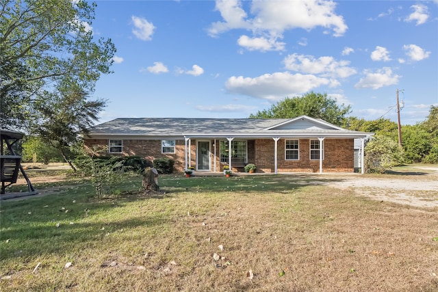 ranch-style home featuring covered porch and a front lawn