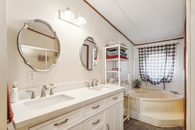 bathroom featuring vanity, lofted ceiling, and a bathtub