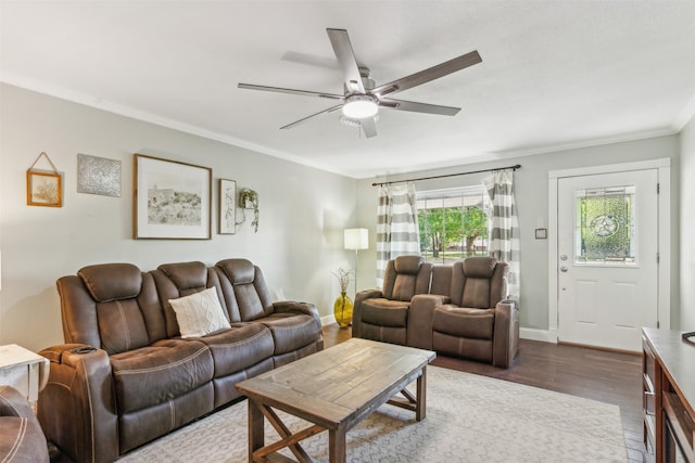 living room with crown molding, dark wood-type flooring, and ceiling fan