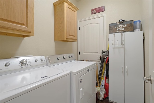 washroom featuring cabinets and washer and clothes dryer