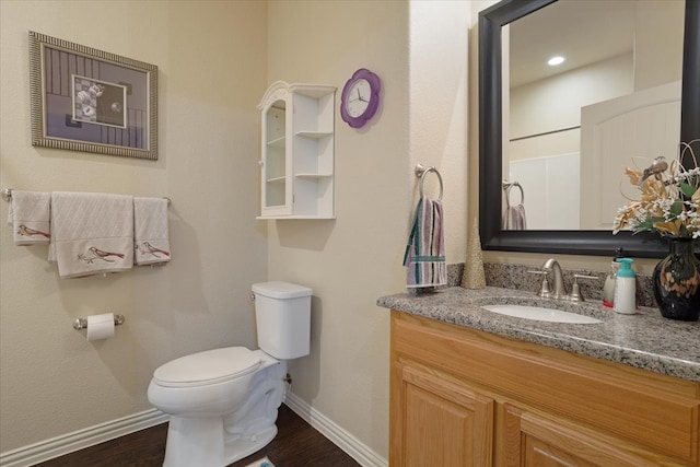 bathroom with vanity, toilet, and hardwood / wood-style flooring